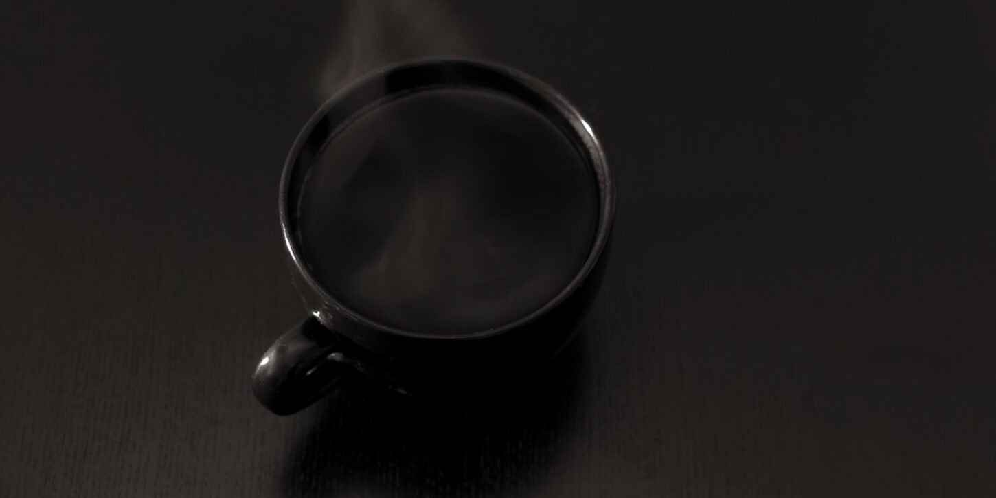 Café e hígado: 355.000 personas y menos riesgo de cirrosis y cáncer Taza de café humeante sobre una superficie oscura