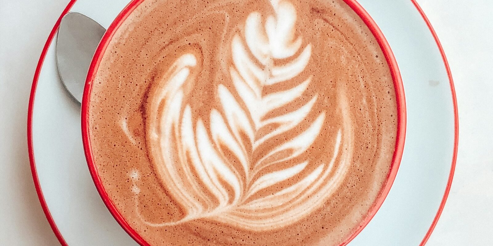 Taza de café con leche con un corazón dibujado en la espuma