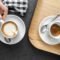 Manos sujetando una taza de cerámica blanca con café durante una pausa tranquila