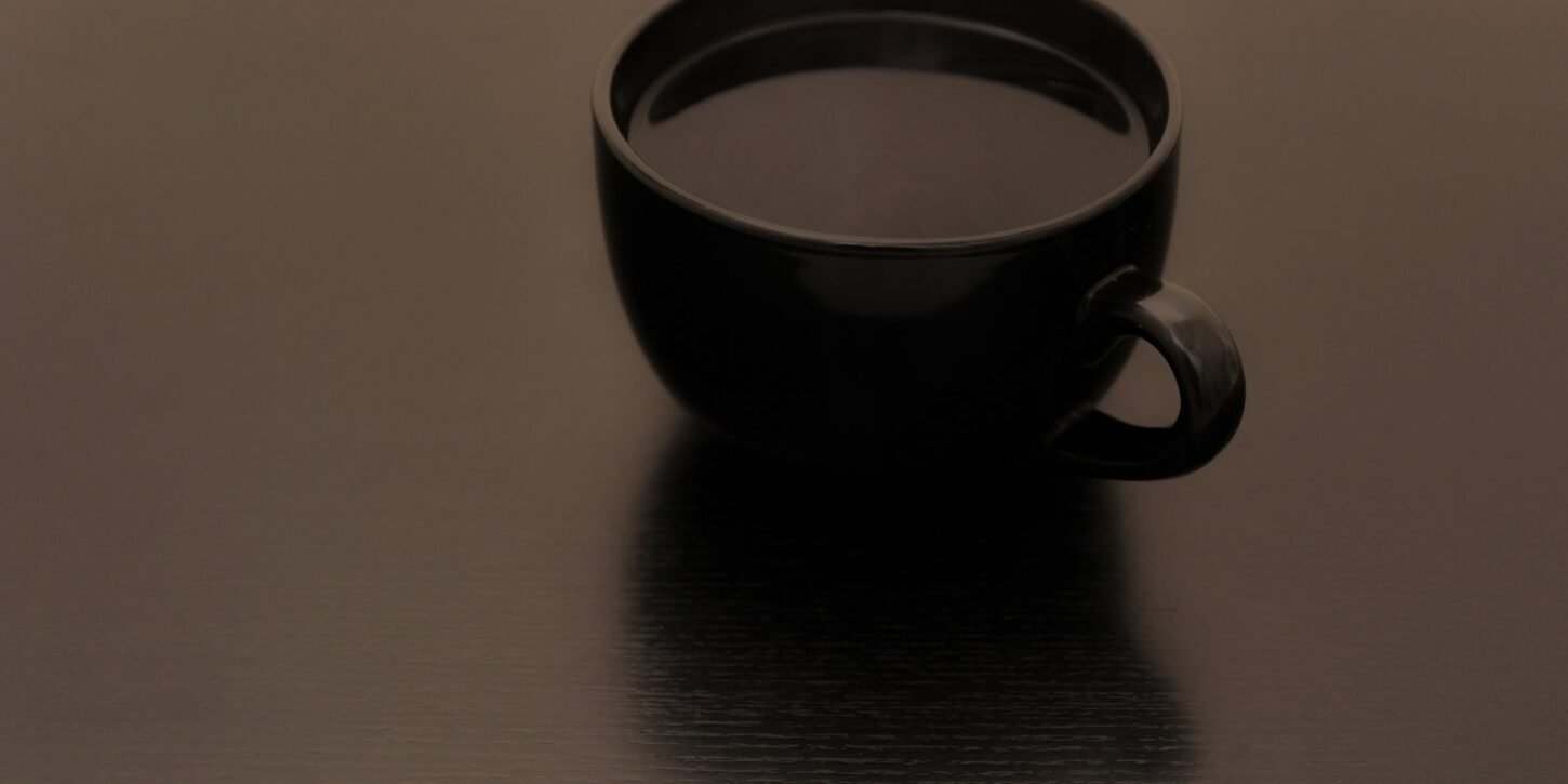 Café y corazón: qué dice la American Heart Association de la cafeína Taza de café solo sobre una superficie oscura