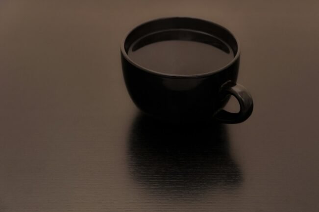 Café y corazón: qué dice la American Heart Association de la cafeína Taza de café solo sobre una superficie oscura