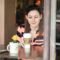 Mujer sentada a una mesa mirando la taza de café que sostiene en la mano