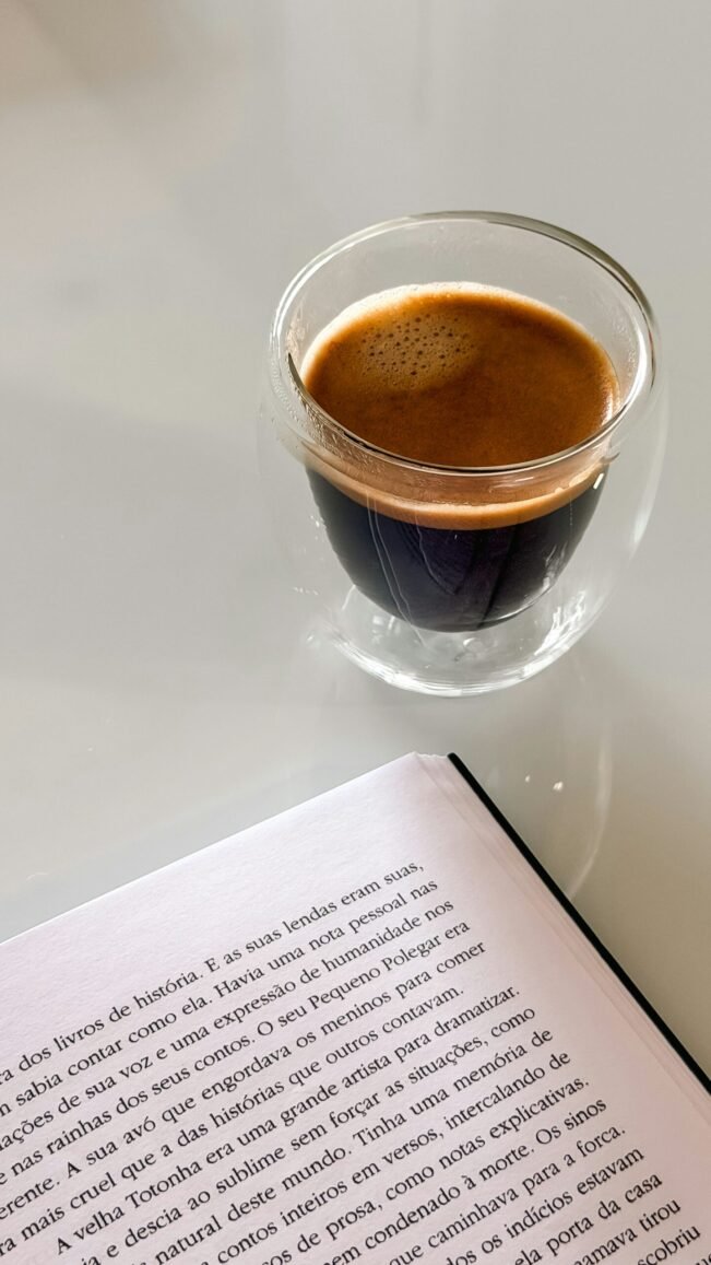 Cafeína y concentración en jóvenes: qué dice un metaanálisis de 14 ensayos Taza de espresso junto a un libro abierto sobre una mesa blanca