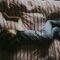 Niño dormido en una cama con sábanas rojas y grises