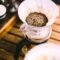Jarra de cristal con café recién filtrado sobre una barra, con fondo desenfocado