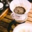 Jarra de cristal con café recién filtrado sobre una barra, con fondo desenfocado