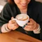 Una mujer bebiendo un capuccino