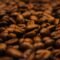 Granos de café tostado oscuro amontonados, donde se forman las melanoidinas que suavizan el amargor de la cafeína