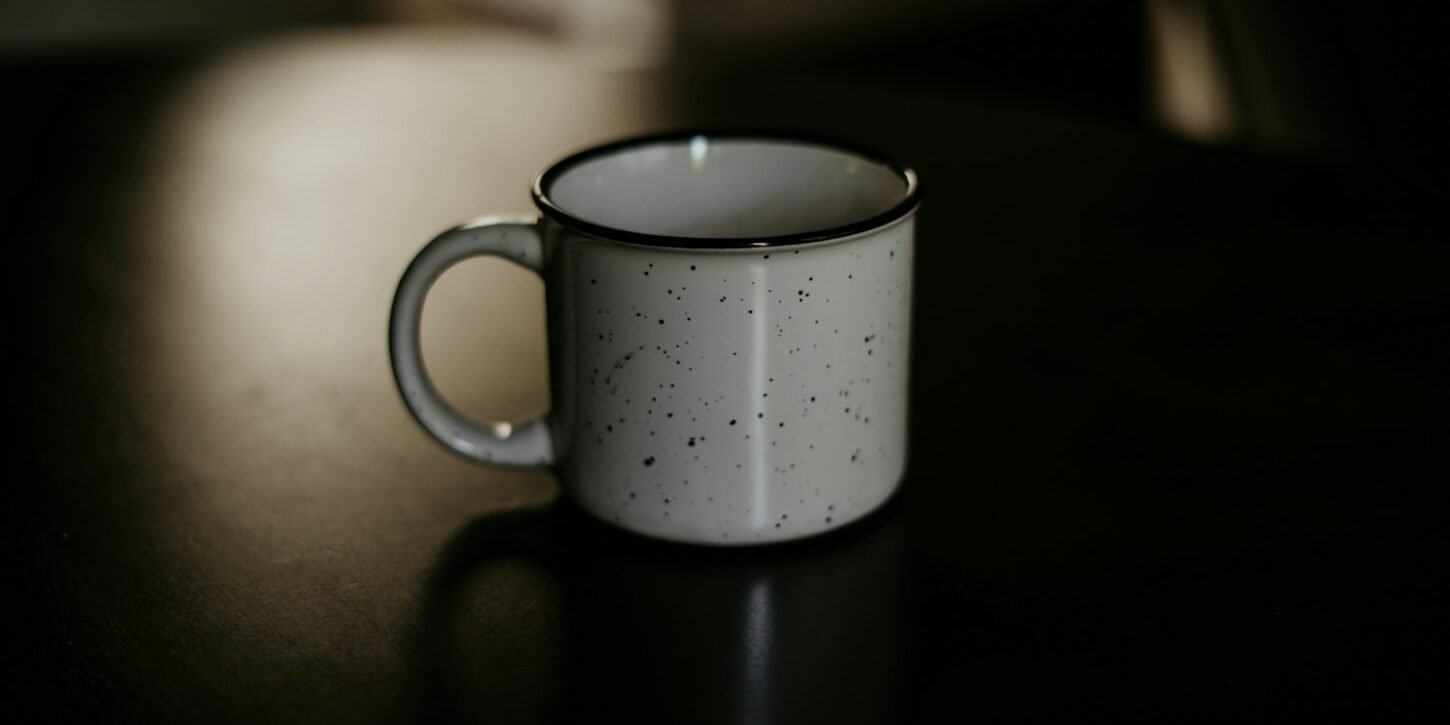 Café solo y en taza de cerámica: qué hace que disfrutemos más el café Taza de cerámica blanca con café solo sobre una superficie oscura