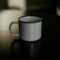 Taza de cerámica blanca con café solo sobre una superficie oscura